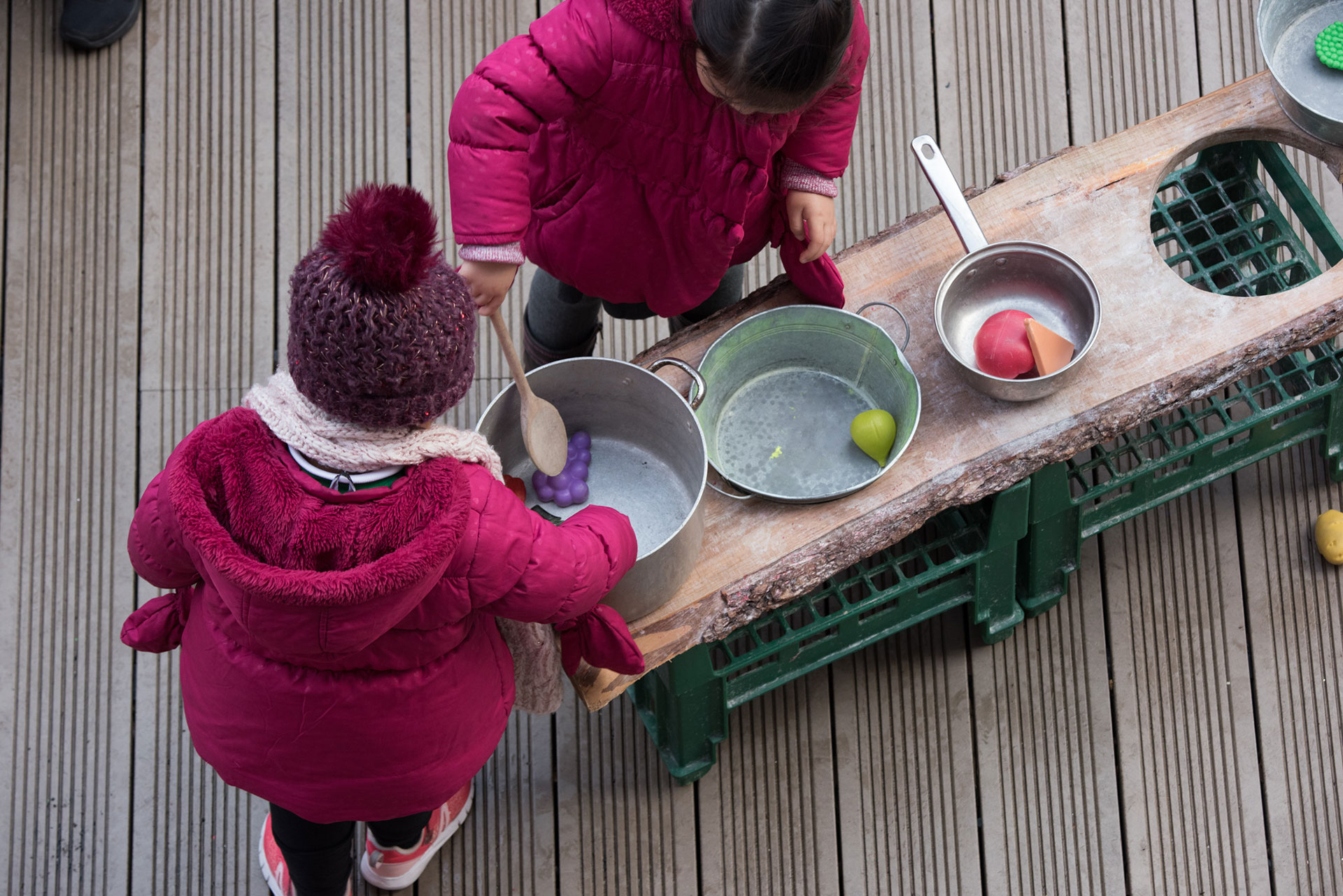 Children playing with plastic cooking equipment and food