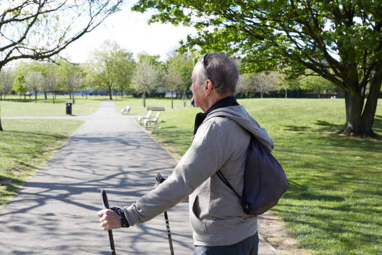 Man walking in the park with walking poles