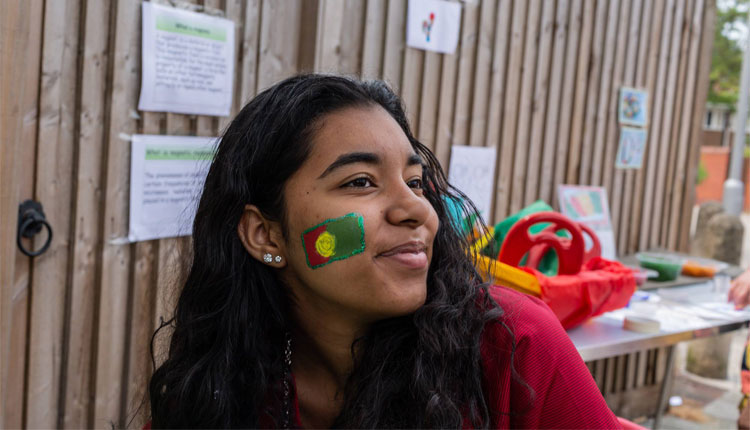 Woman with Portugal flag painted onto the side of her face