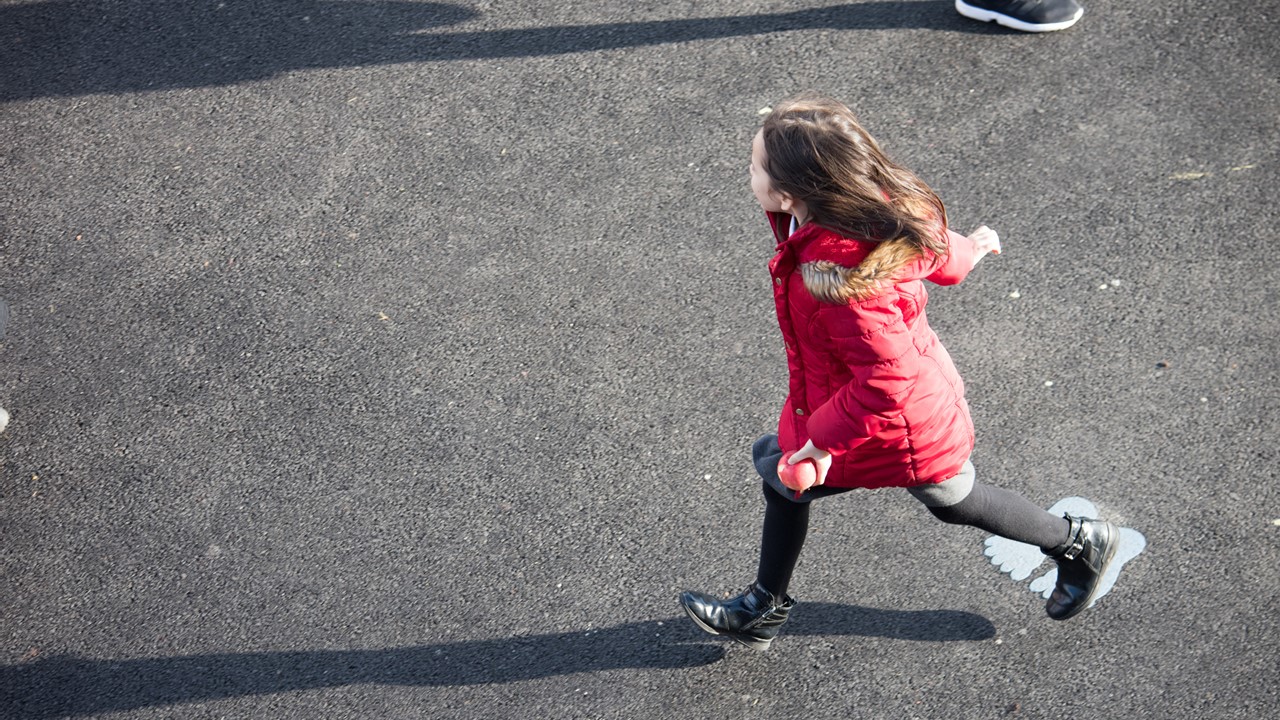 Little girl running in playground