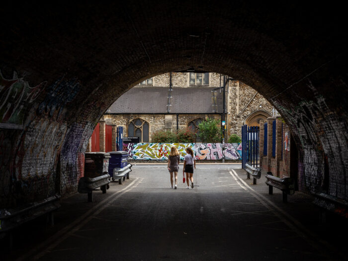 Two people walking through an underpass in Peckham