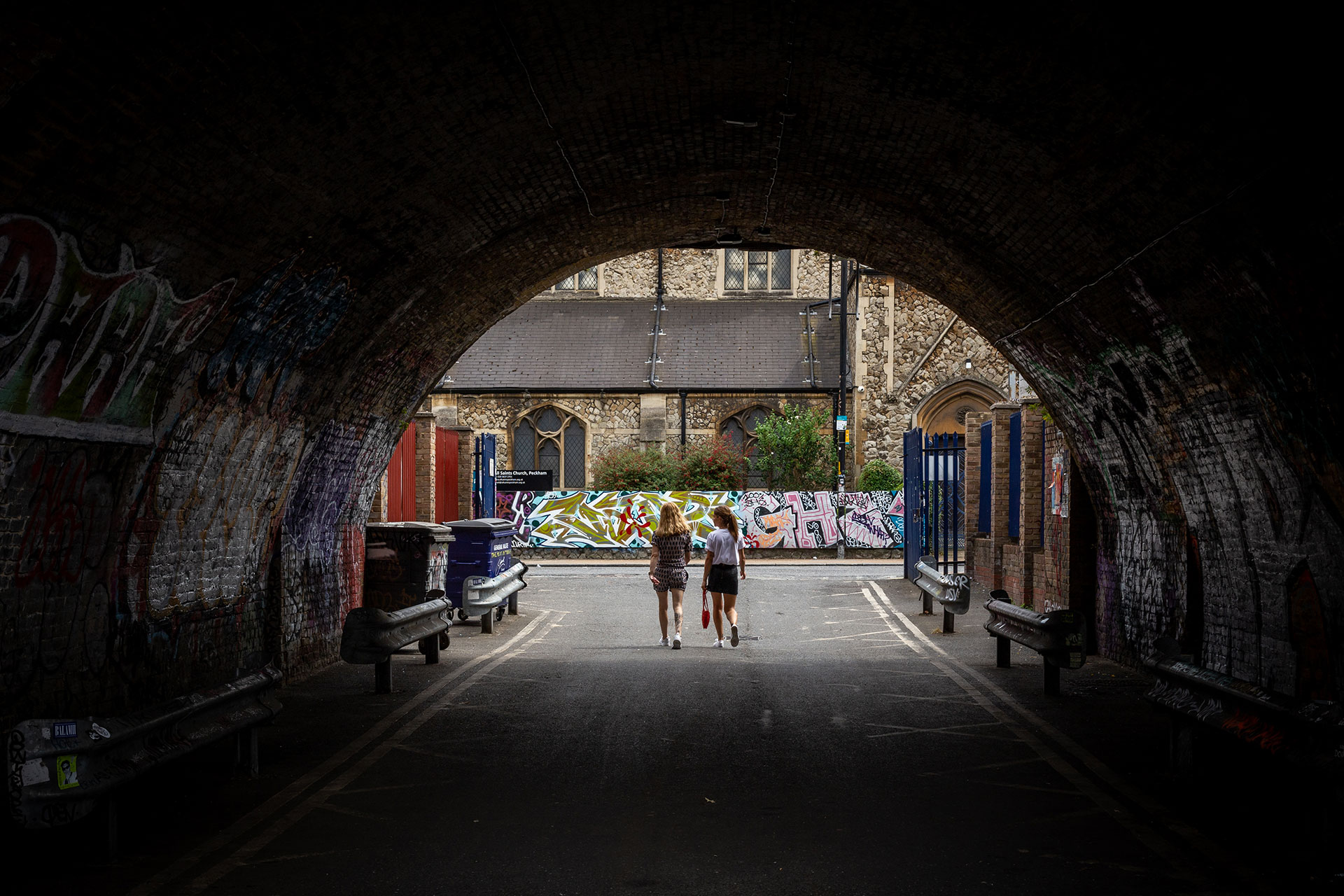 Two people walking through an underpass in Peckham