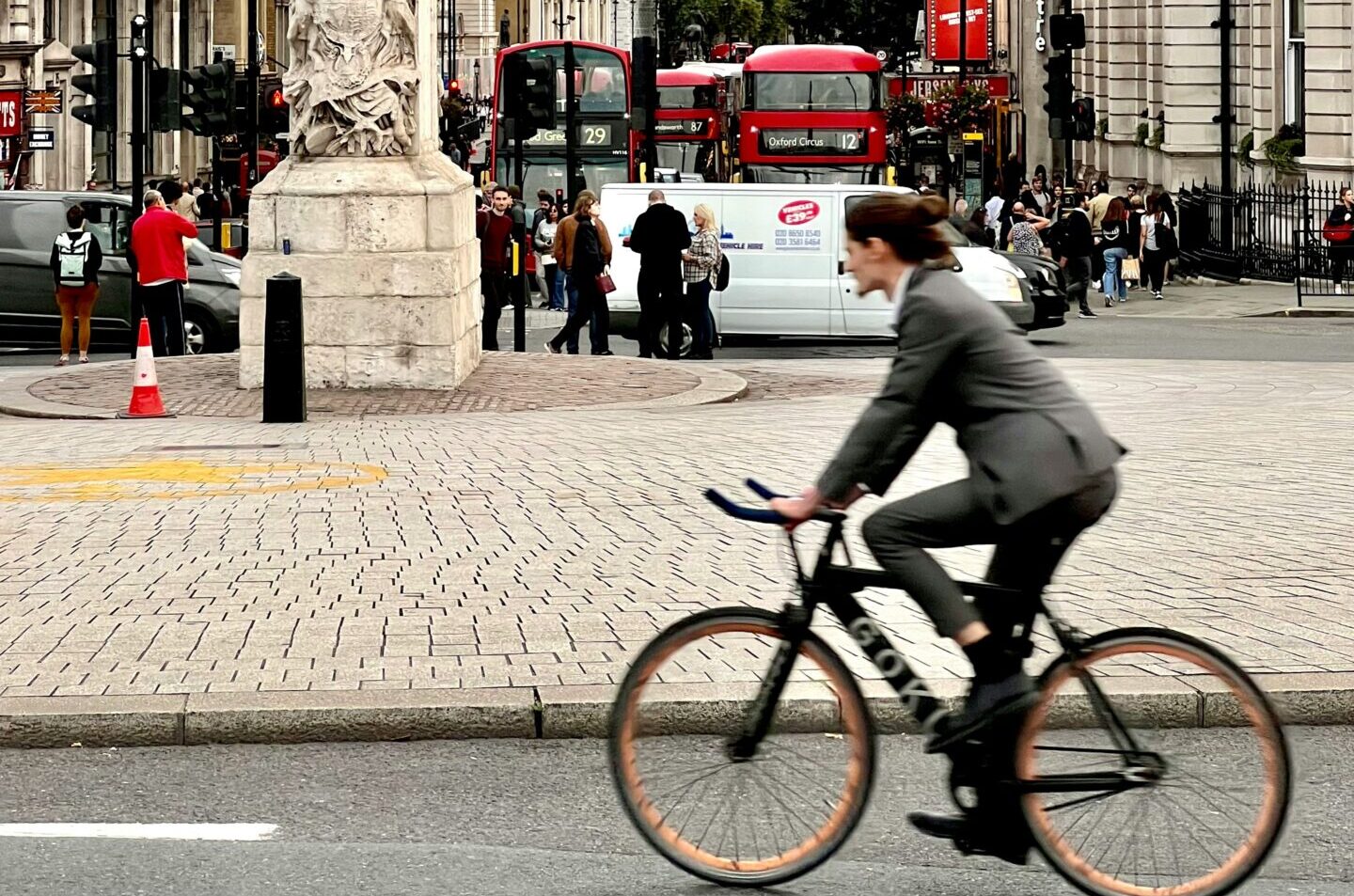 Roadway in City of London, with buses, vans, and a cyclist. Photograph by Ruoyu Li.