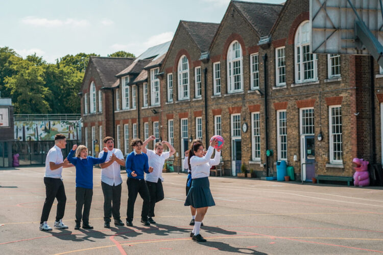 Children in a school playground playing a ball game.