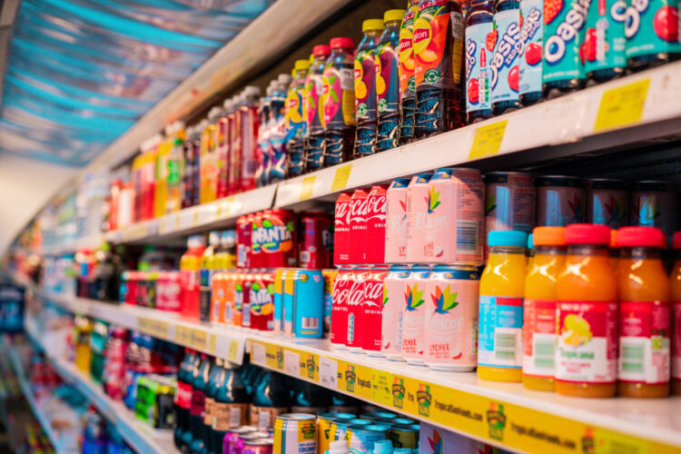 Soft drinks and juices on a shop shelf.