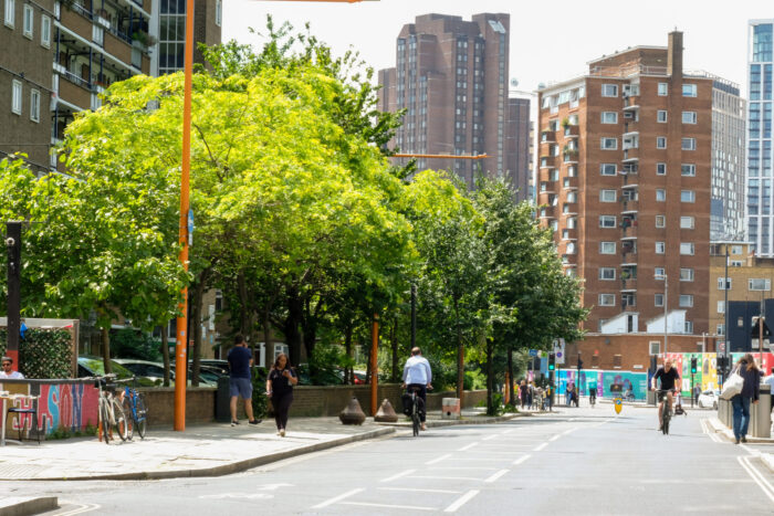 Union Street in Southwark. There are trees on the pavement. People are walking along the road. In the distance are some flats.