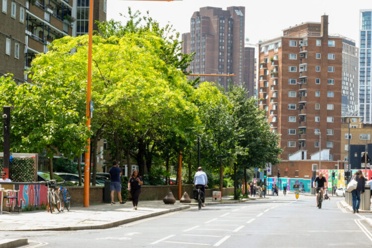 Union Street in Southwark. There are trees on the pavement. People are walking along the road. In the distance are some flats.