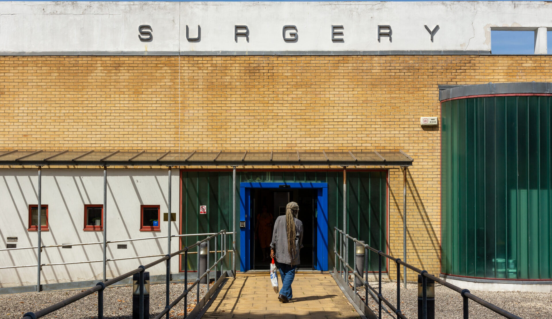 A person is entering a GP surgery.