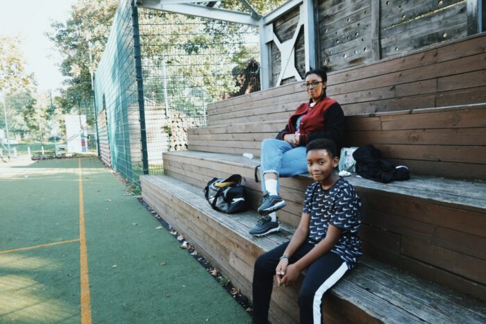 Two%20people%20sitting%20outdoors%20and%20facing%20the%20camera