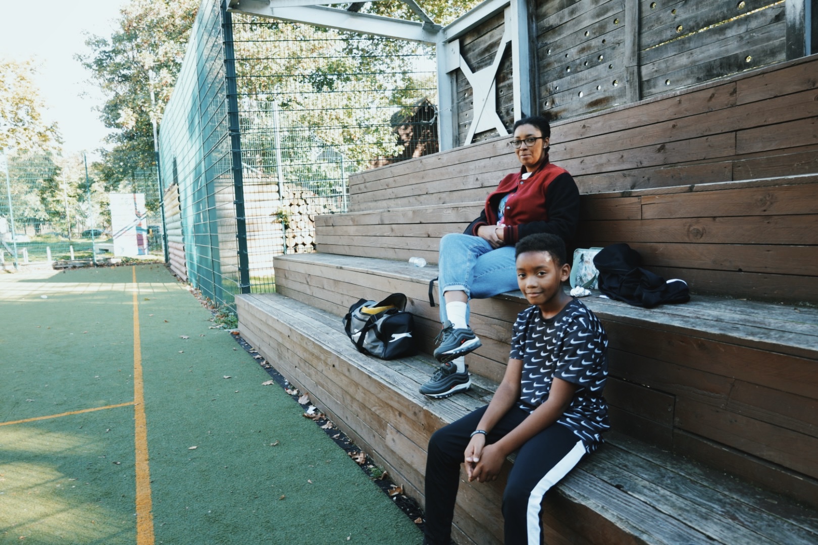 Two people sitting outdoors and facing the camera