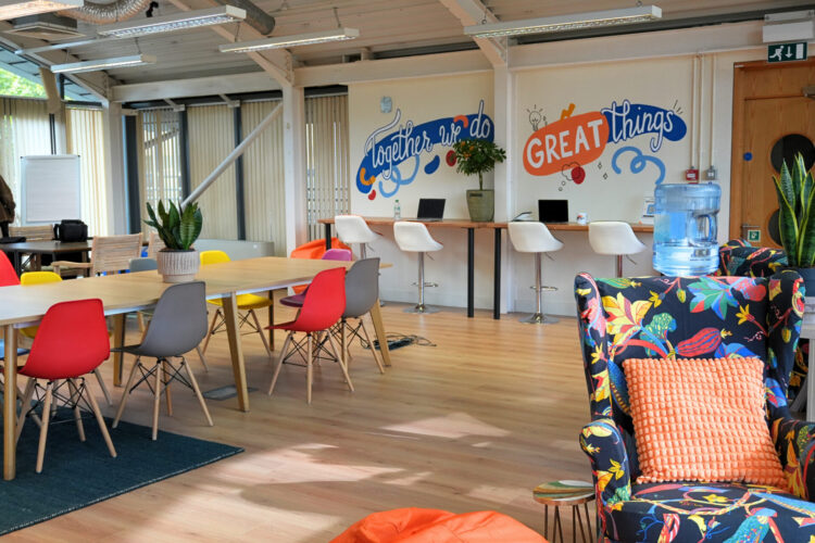 The Enterprise Hub. Chairs around a table. Computers on a desk.