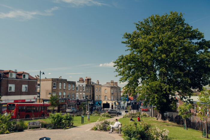 1.%20A%20street%20with%20shops%20and%20restaurants.%20In%20the%20foreground%2C%20there%20is%20a%20public%20park%20where%20people%20are%20sitting%20on%20benches%20and%20on%20the%20grass.%20There%20are%20flowers%20and%20trees.