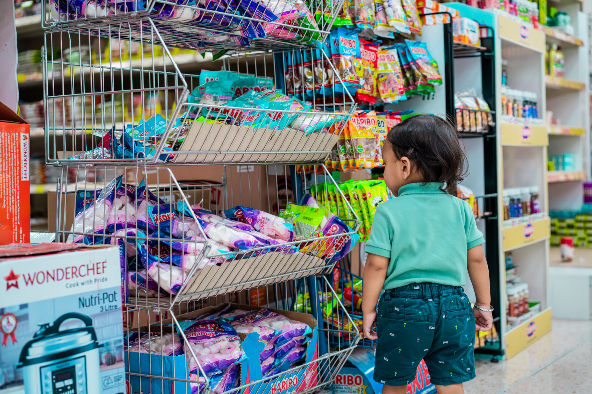 A child looking at food products on a shelf in a supermarket